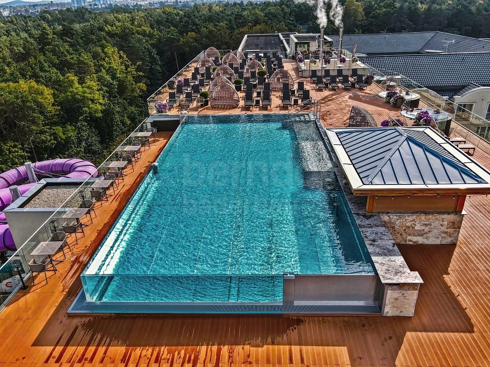 Hotelový strešný bazén s infinity skleneným prelivom